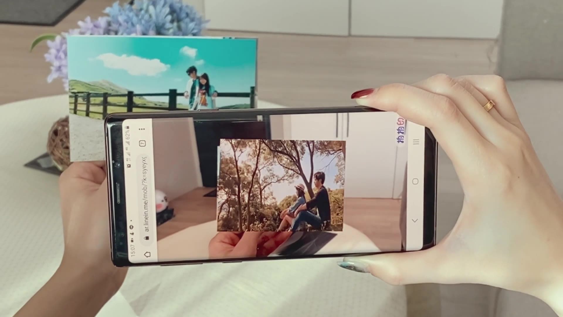 A phone pointed at a print on the table; the video plays right on the photo