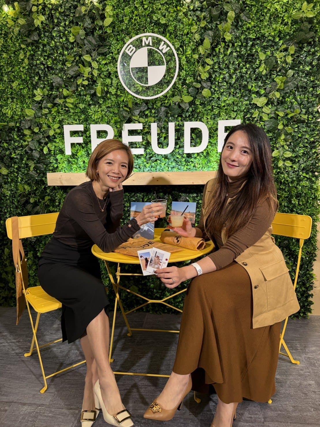 BMW FREUDE brand event — guests enjoying signature drinks by the green wall