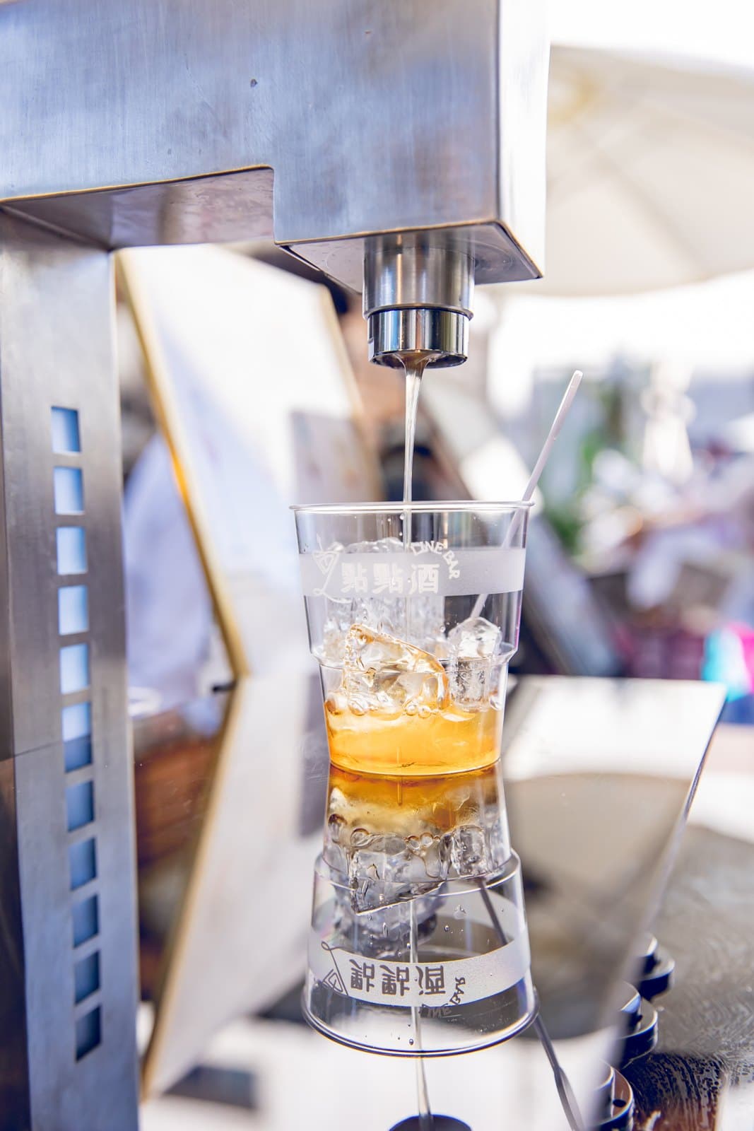 Close-up of the machine pouring a cocktail over ice