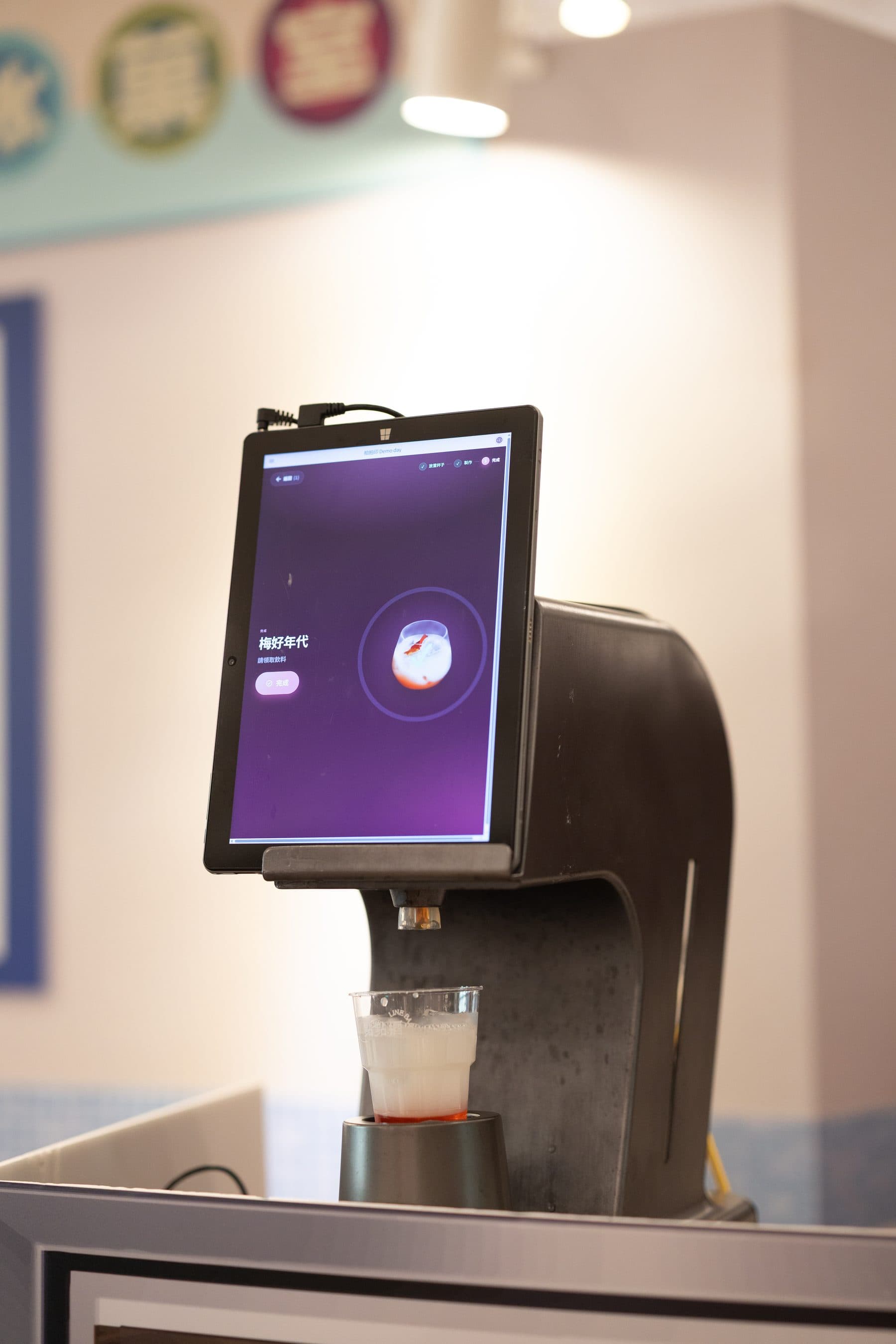 The smart bar dispensing a drink, the screen showing a mixing animation