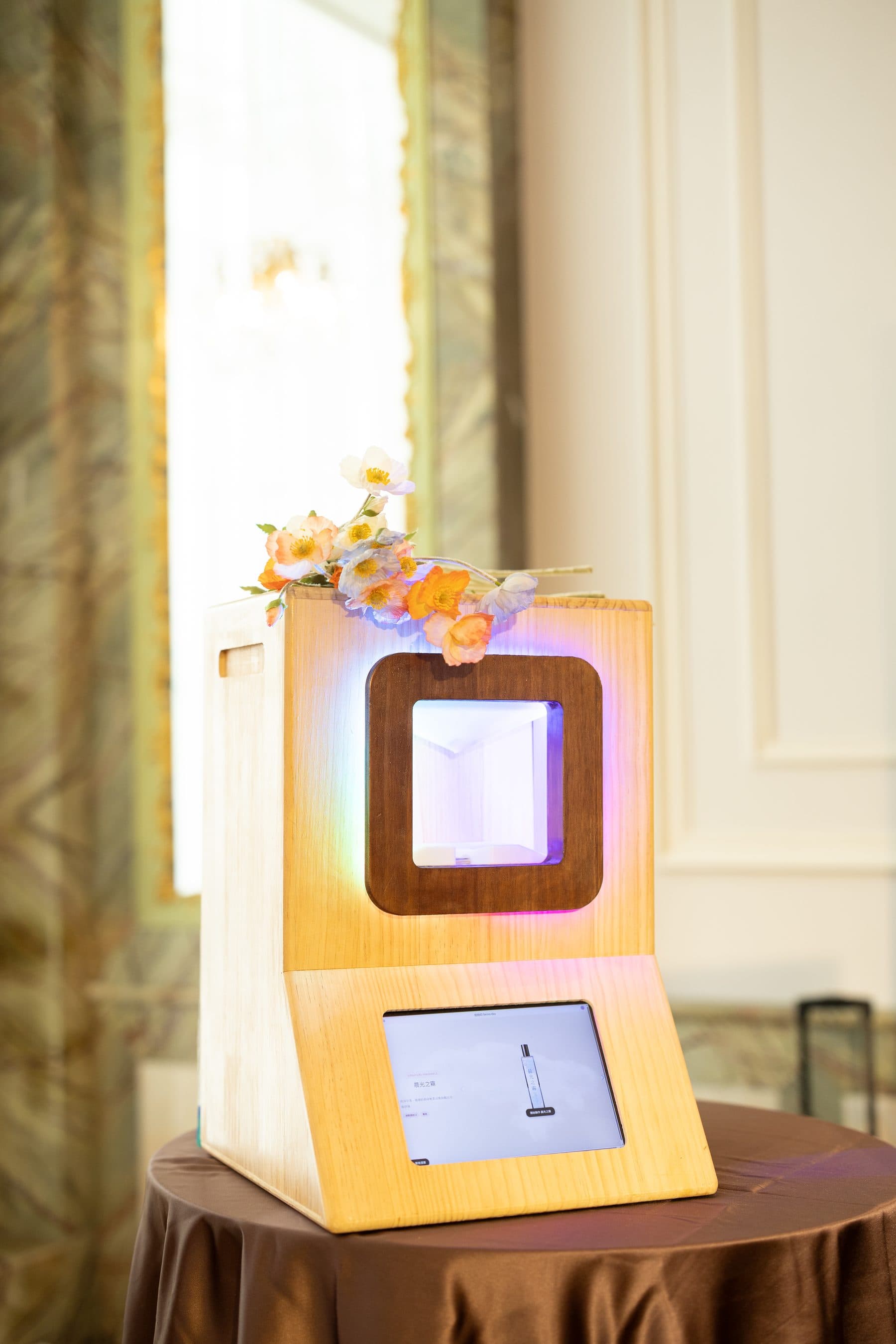 The scent machine itself — wooden housing with a lit centre panel and a screen below listing the available scents
