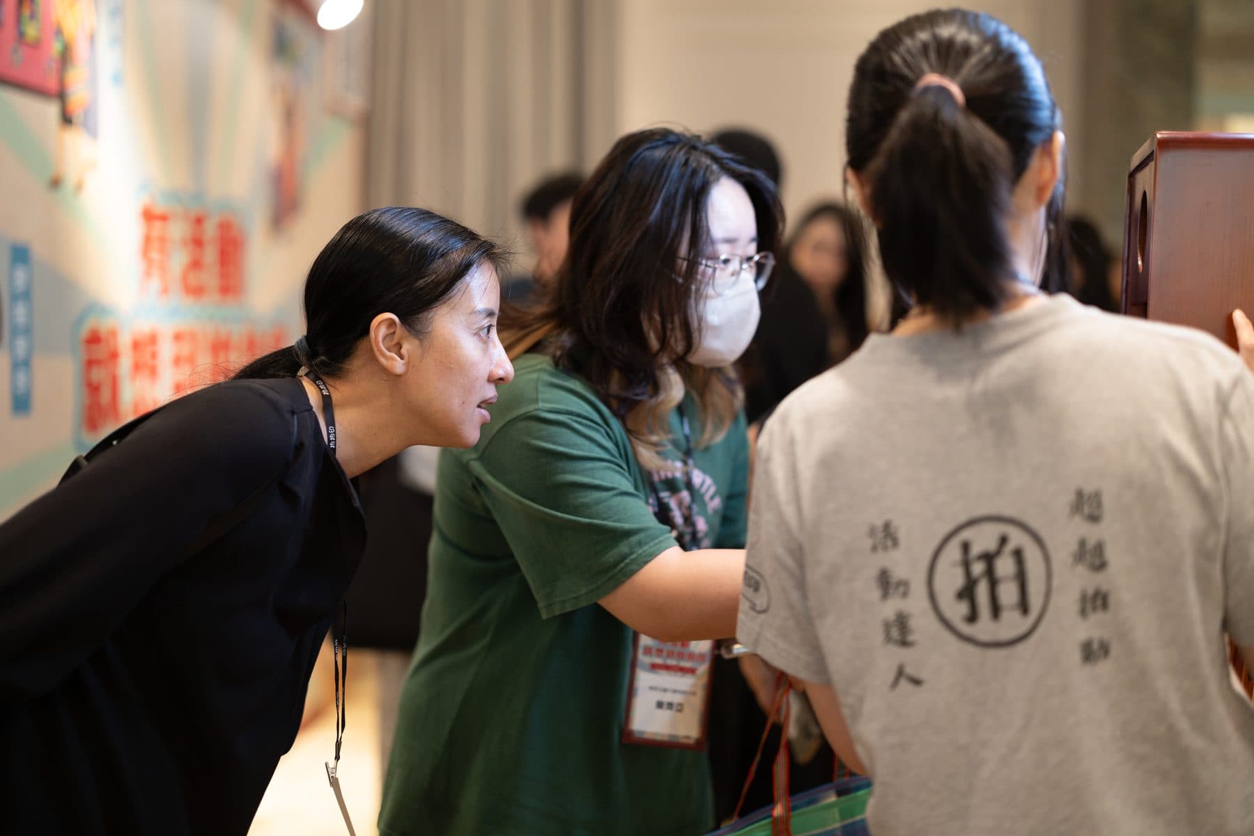 A crew member guiding two guests at the video guestbook stand