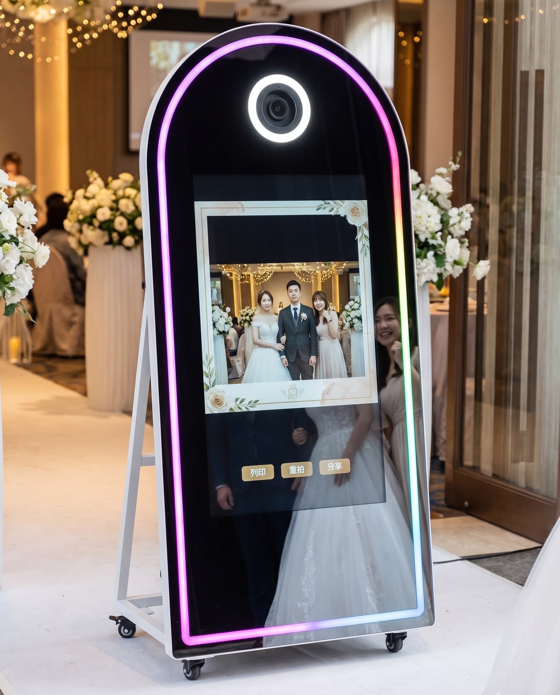 A couple posing at the magic mirror photo booth at a wedding