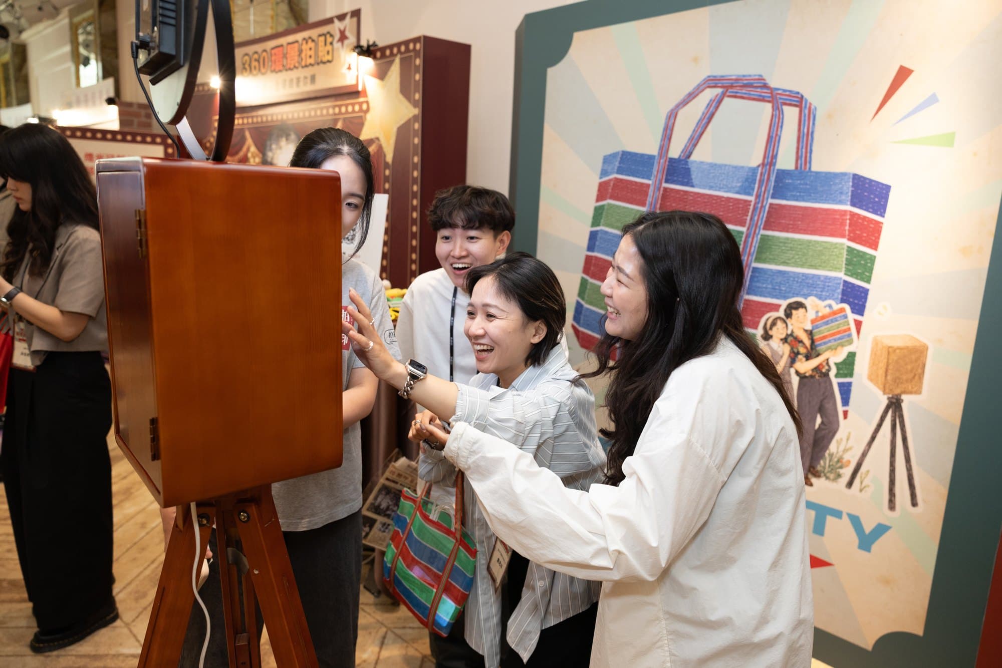 Guests laughing at the retro booth screen, pointing at the shot they just took