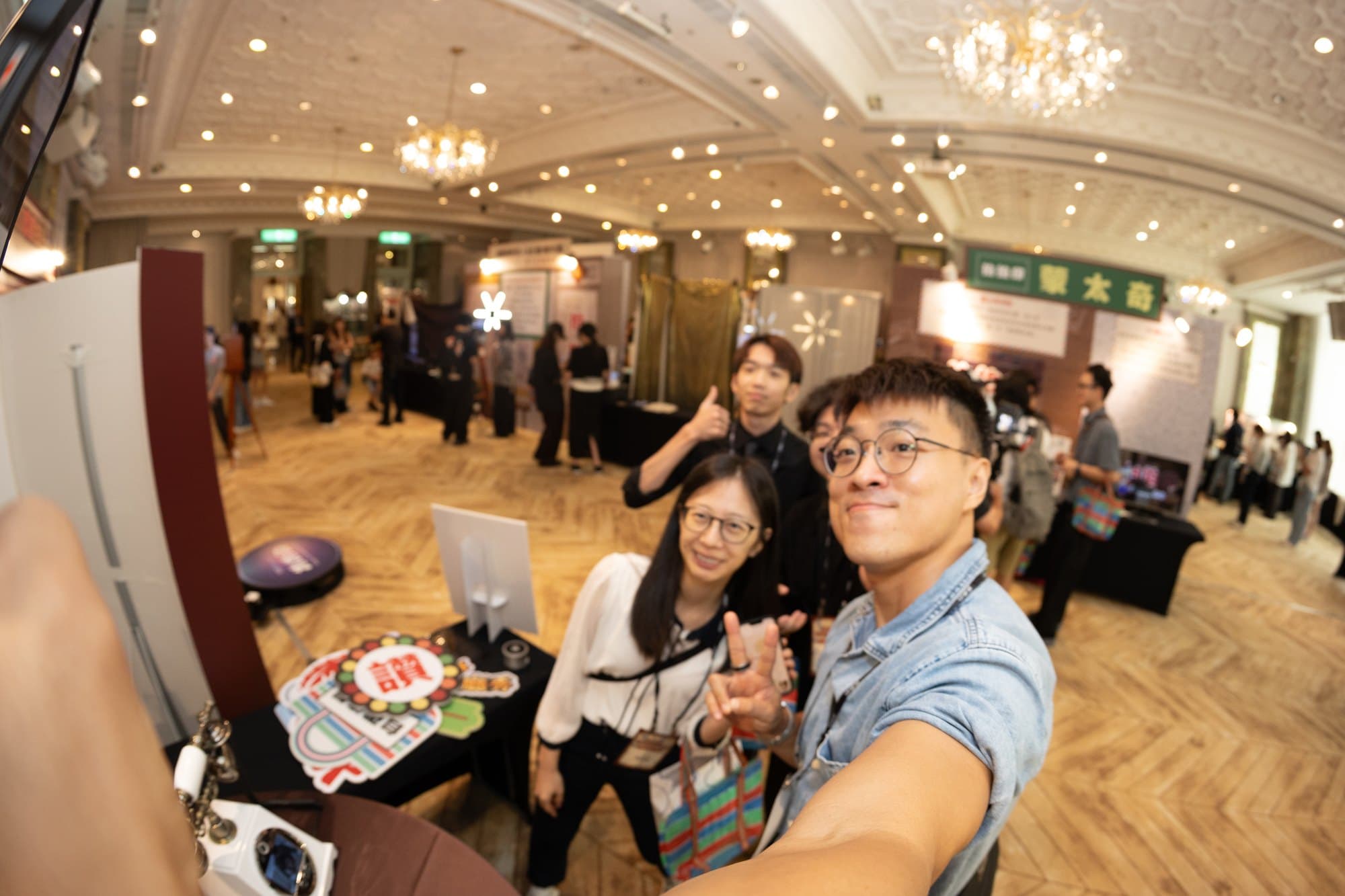 Guests taking a selfie at the retro booth area, the ballroom visible behind