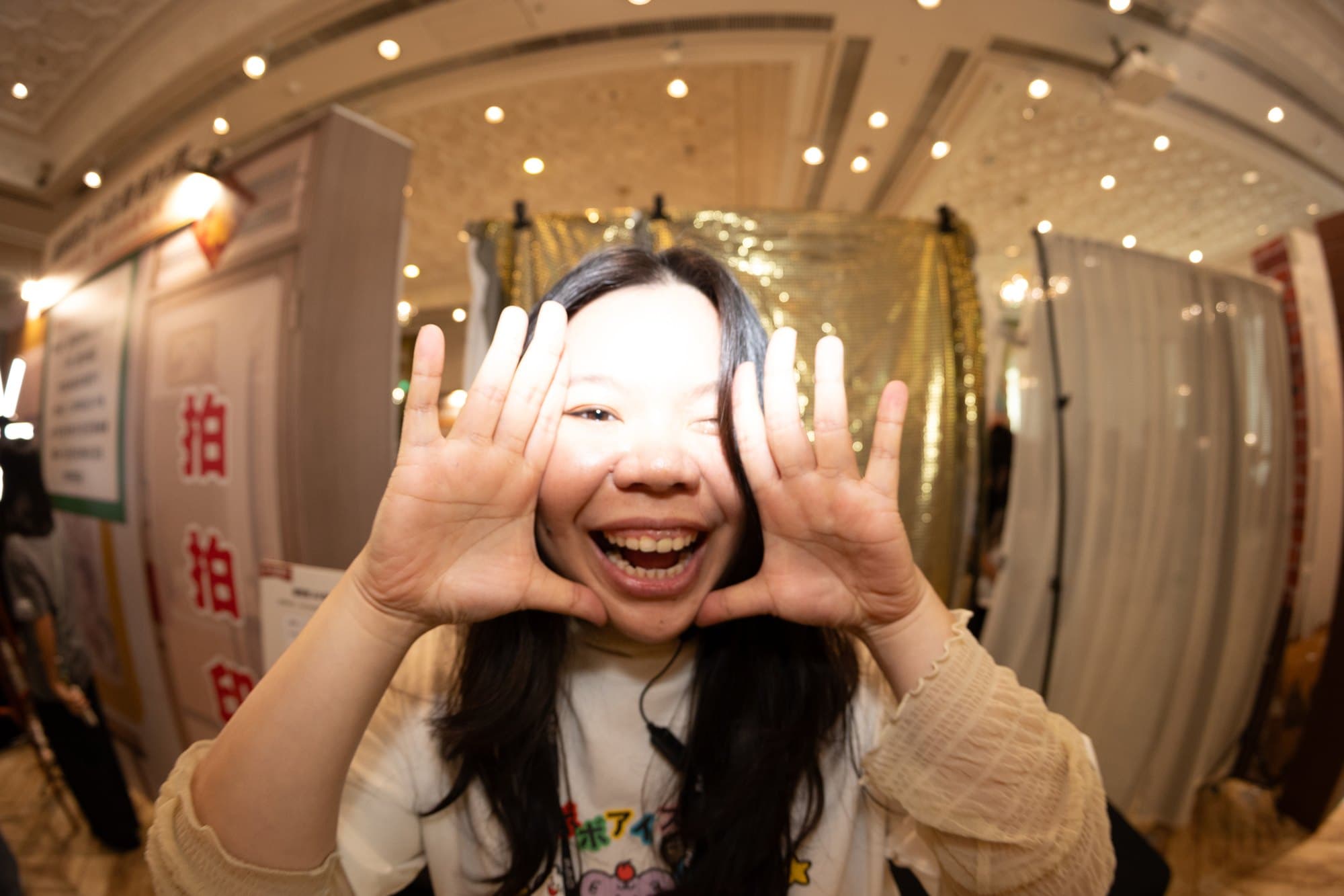 A guest framing her face with her hands, beaming at the retro booth