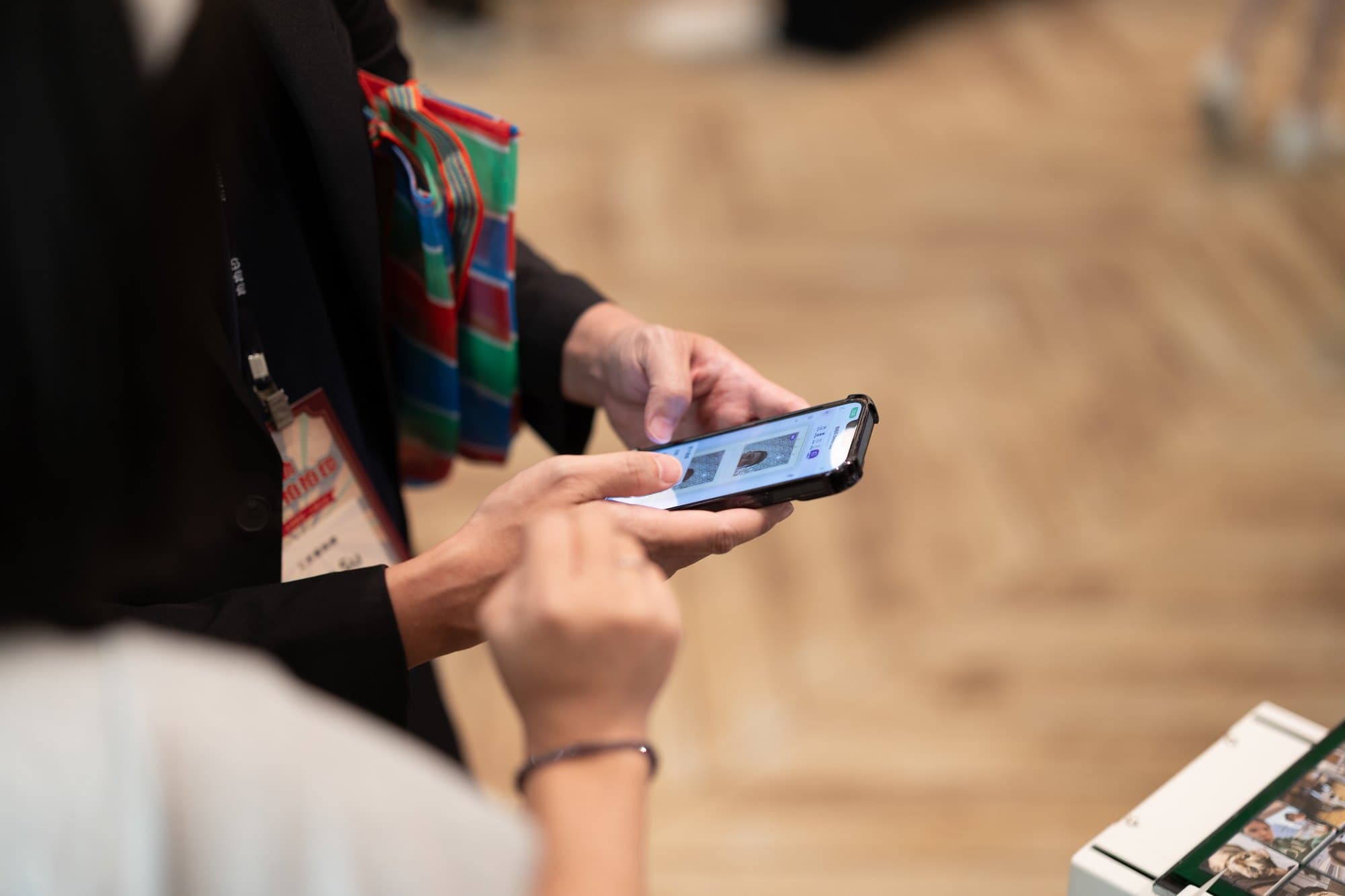 A guest picks a layout on their phone, with the photo printer and finished prints just to the right